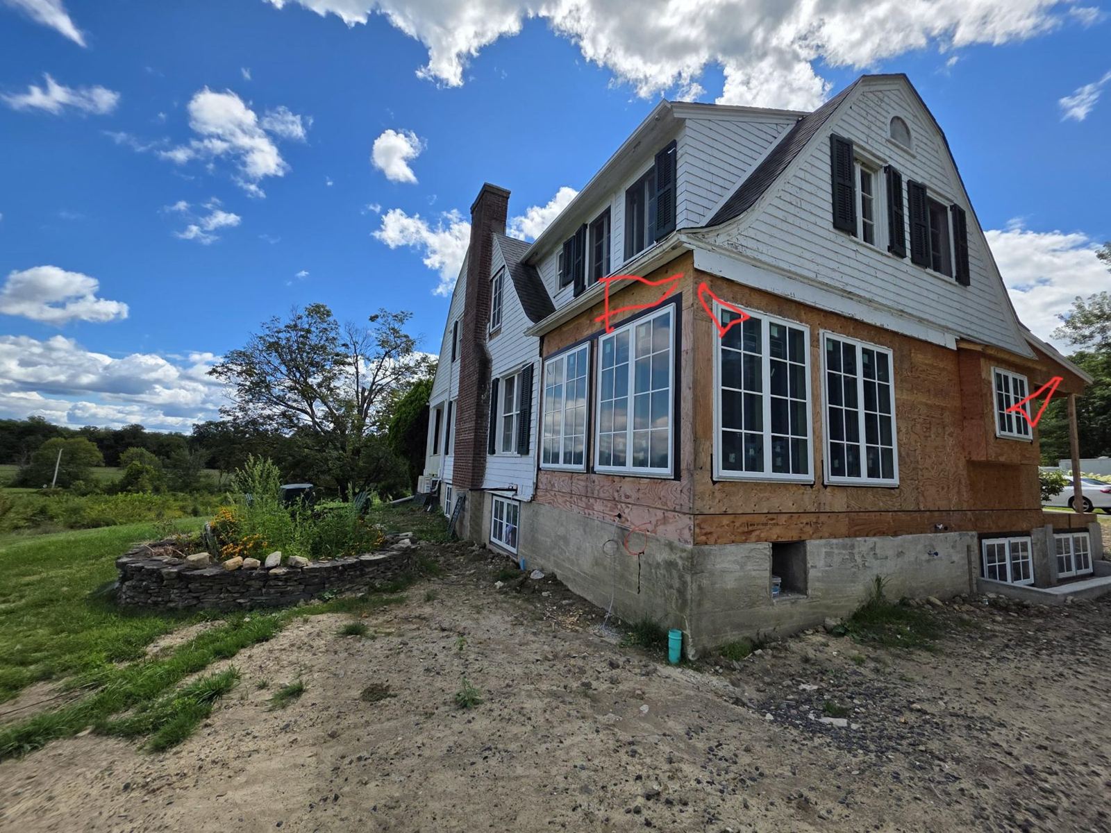 Sheathed addition with new windows on a gambrel-roof house