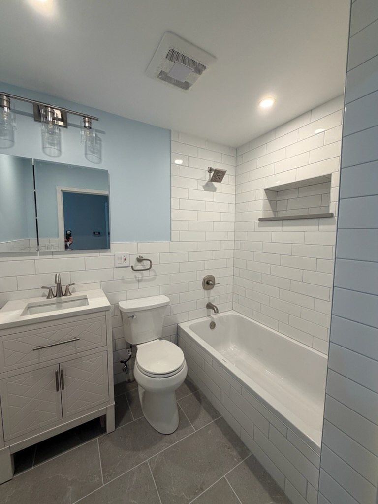 Bath with subway tile tub, niche and pale blue walls