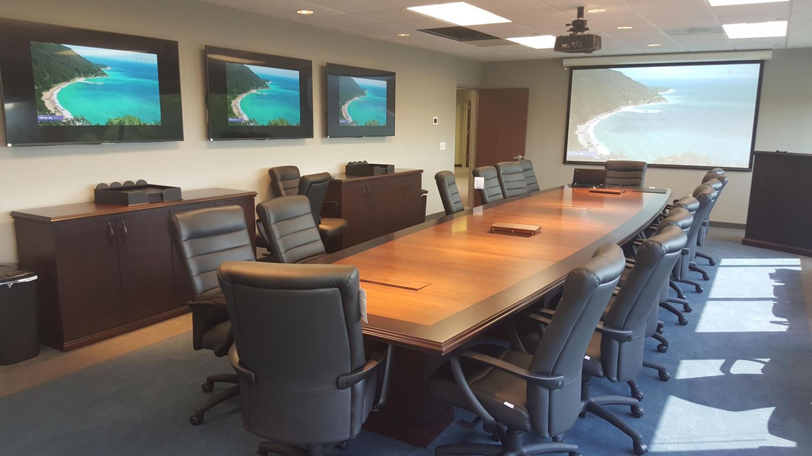 Boardroom with three displays, projector, screen and table connectivity