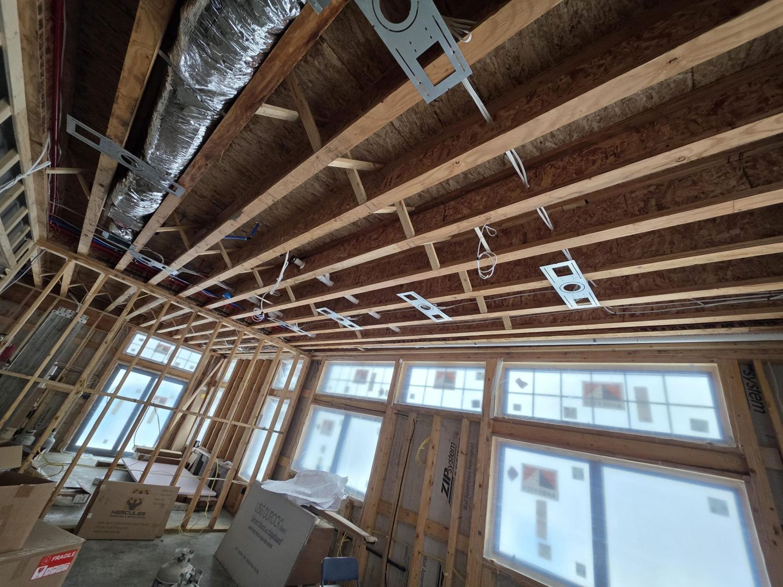 Open joist ceiling with ductwork and speaker brackets during rough-in