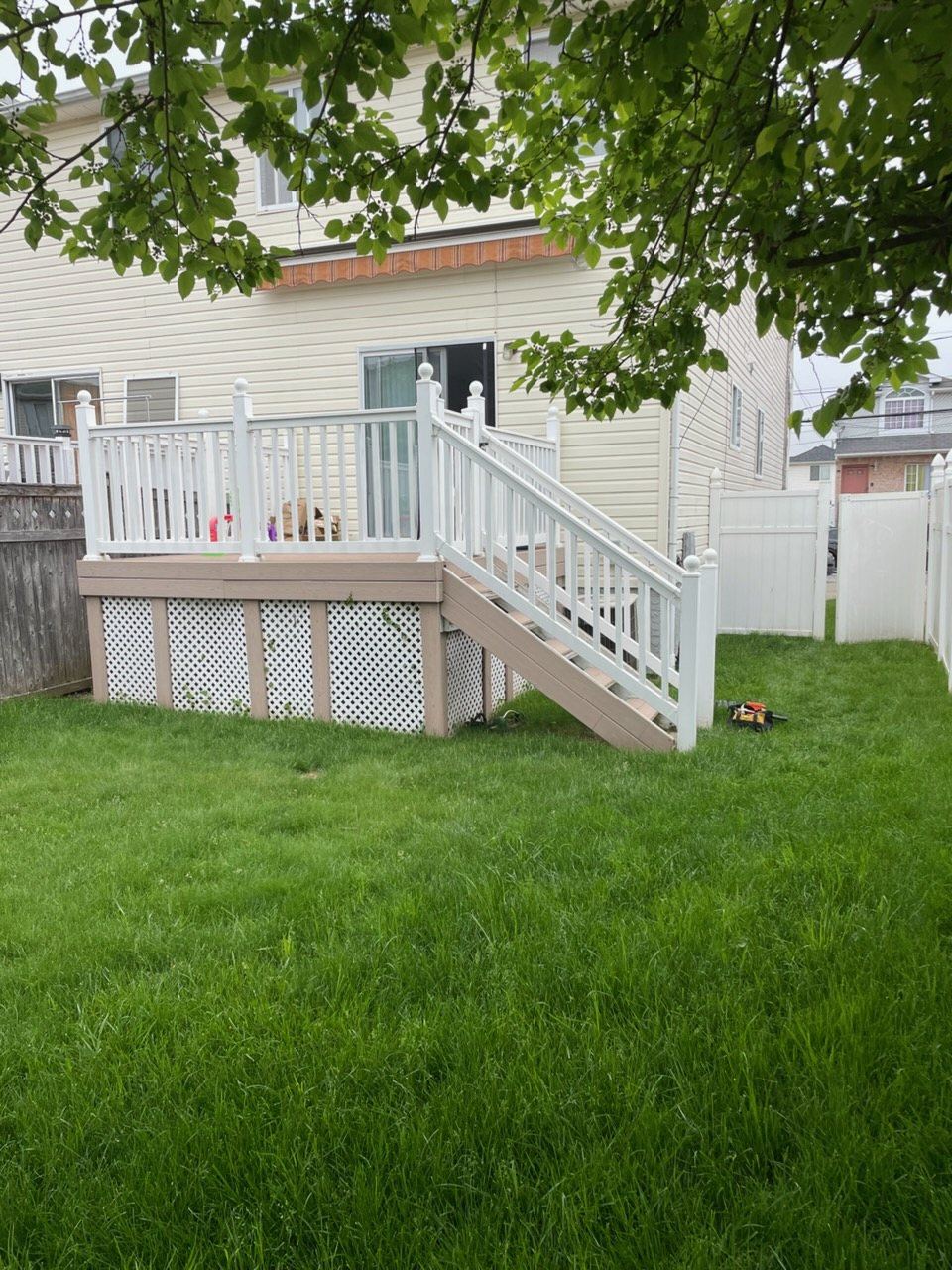 New composite deck with white railings over a lawn