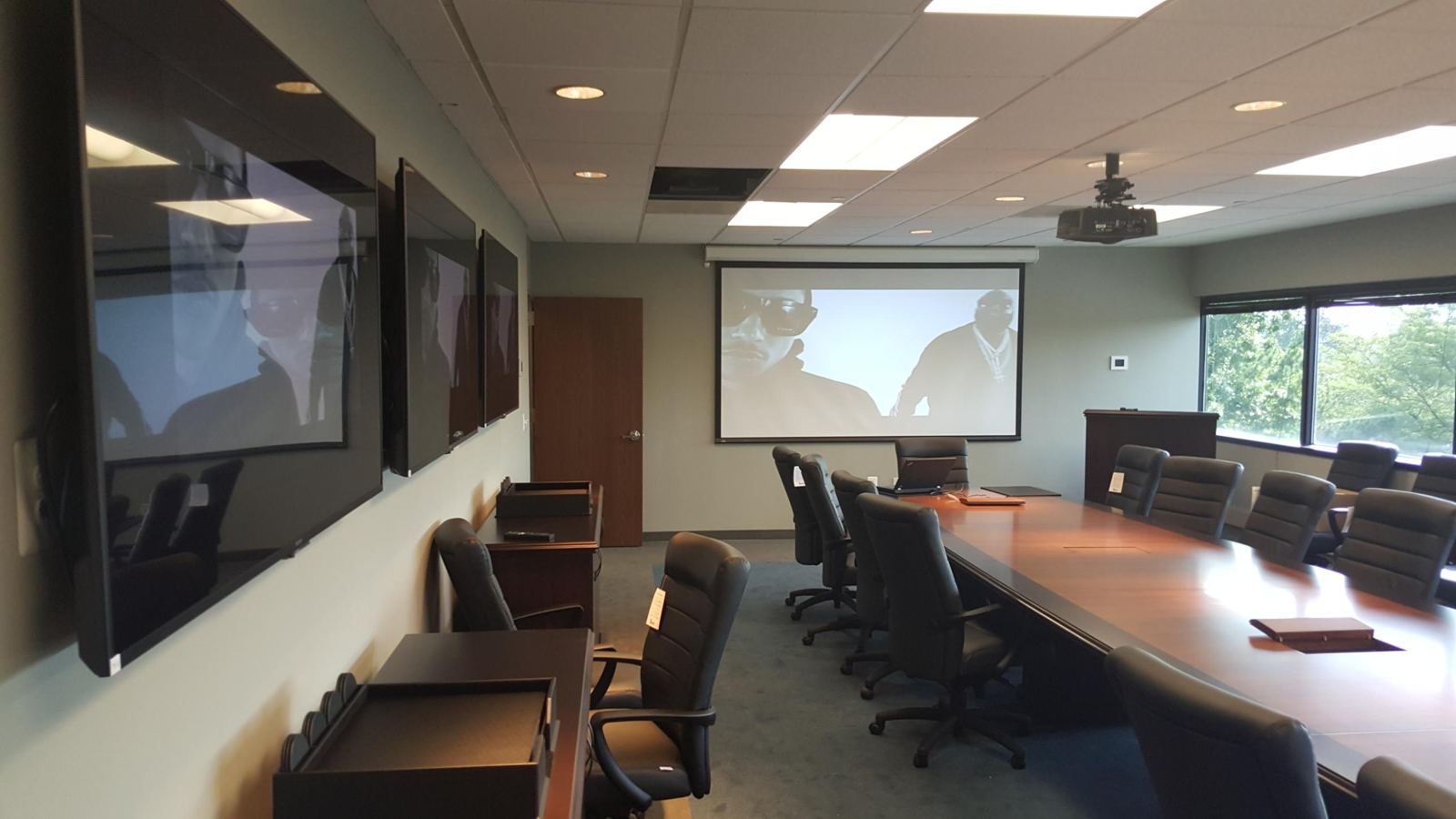 Boardroom with three wall displays and a ceiling projector