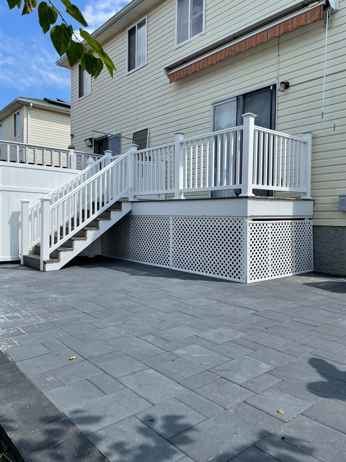 Raised deck and stairs over a new gray paver patio