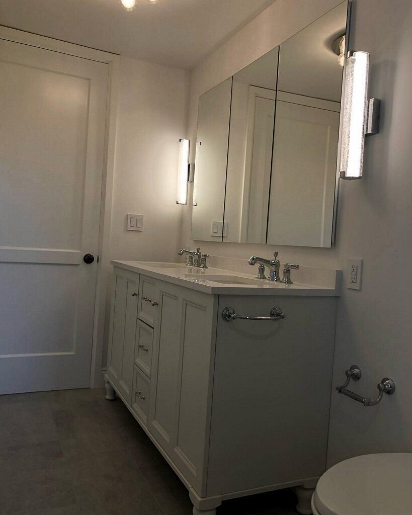 Double vanity with medicine cabinets and vertical sconces