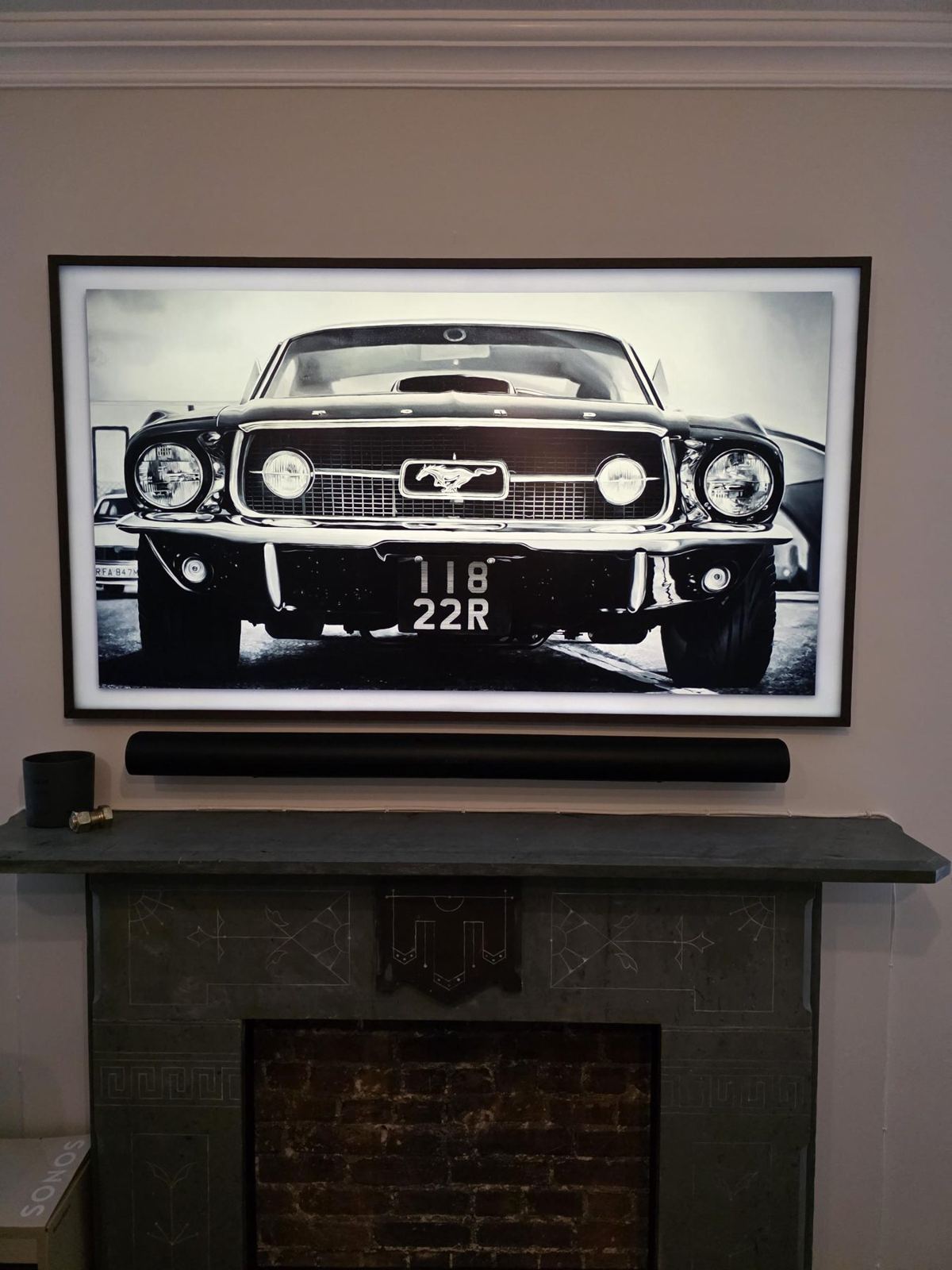 Art-mode TV and soundbar over a restored marble mantel