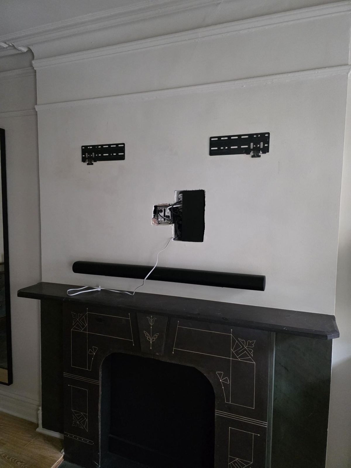 Open recessed box and mount brackets above a marble mantel