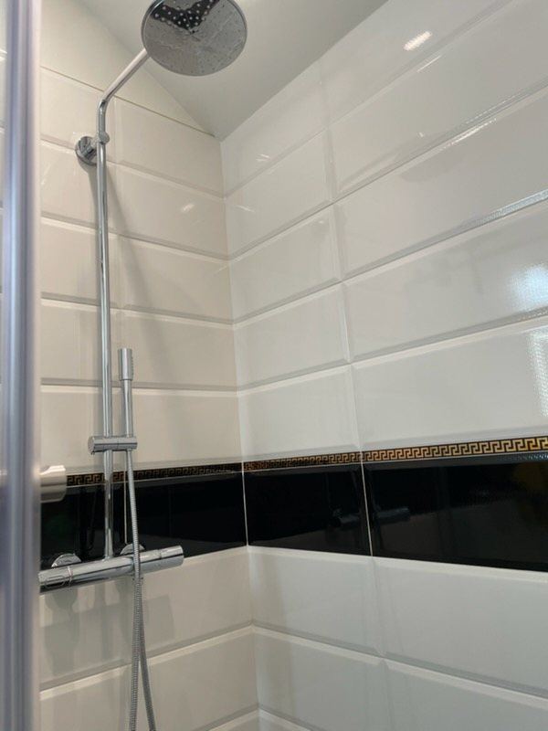 Rain shower with black and gold Greek key tile band