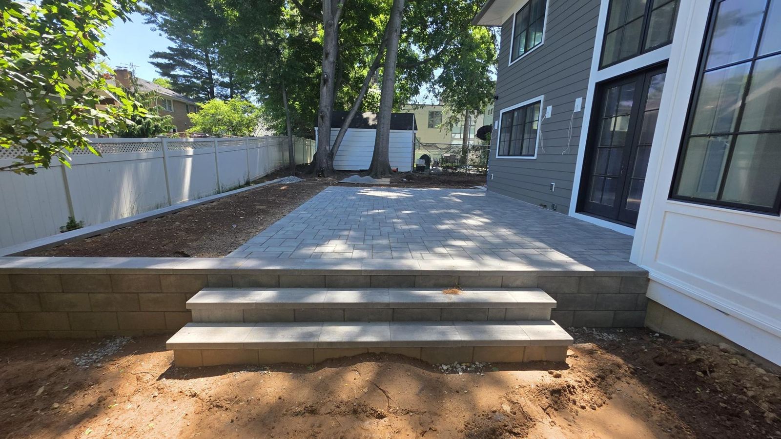New paver patio with stone steps and retaining wall