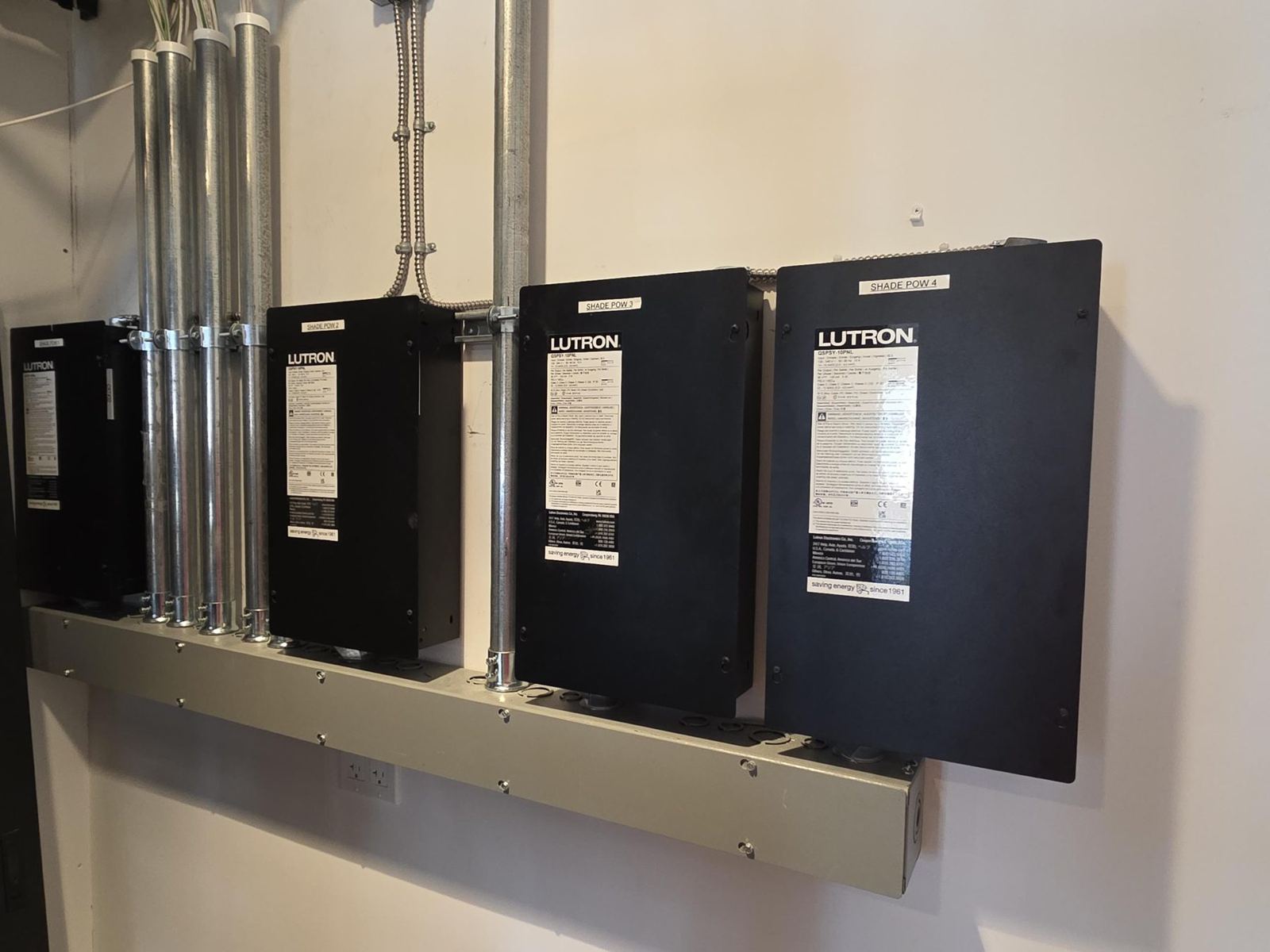 Four labeled shade power panels mounted over a wireway