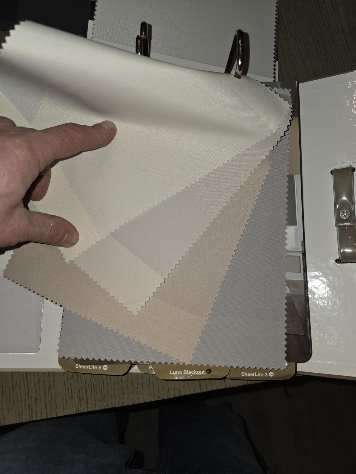 Shade fabric swatches held up to a window during selections