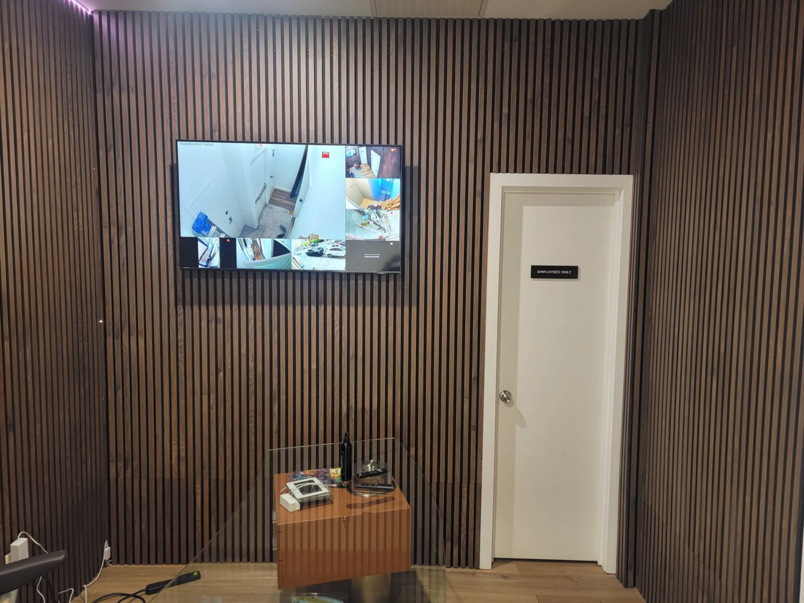 Wood slat wall with a camera monitoring display in a retail back office