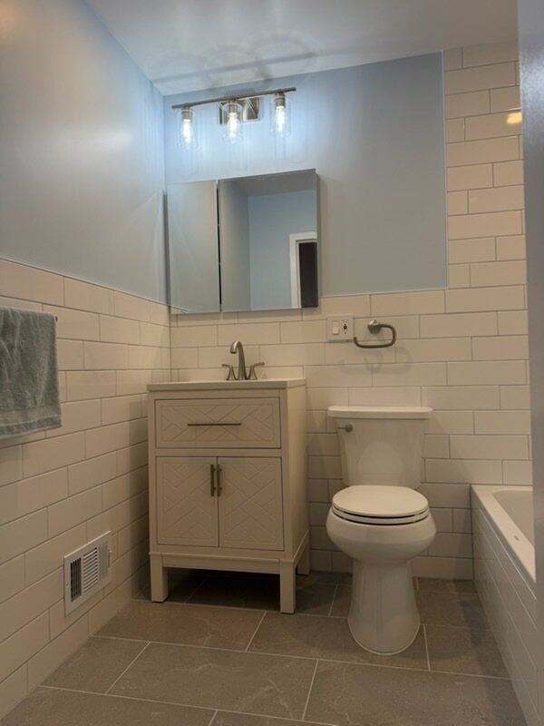 Vanity with medicine cabinet and subway tile wainscot