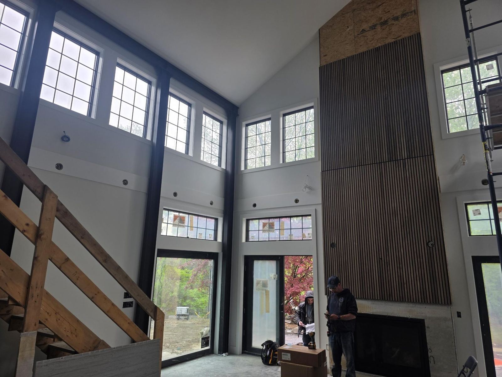 Vaulted great room with a finished wood slat wall over the fireplace