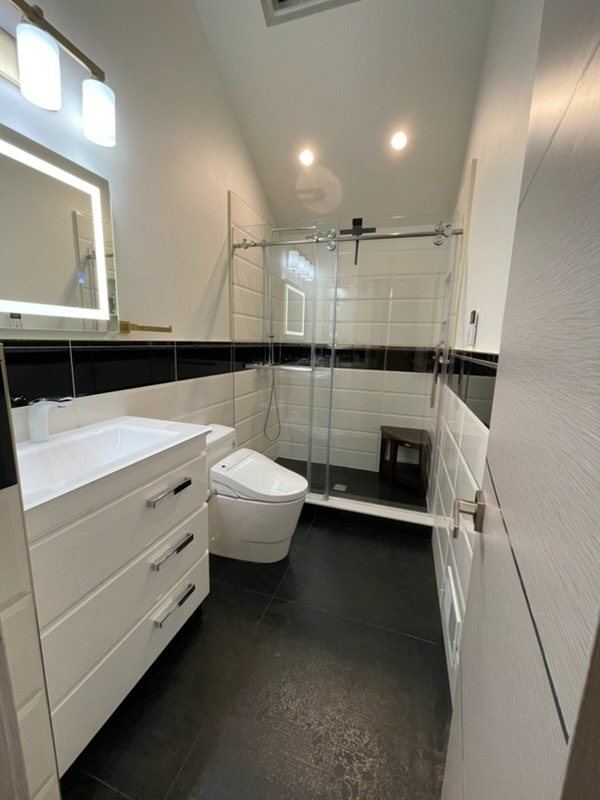 Walk-in glass shower beside a white floating vanity